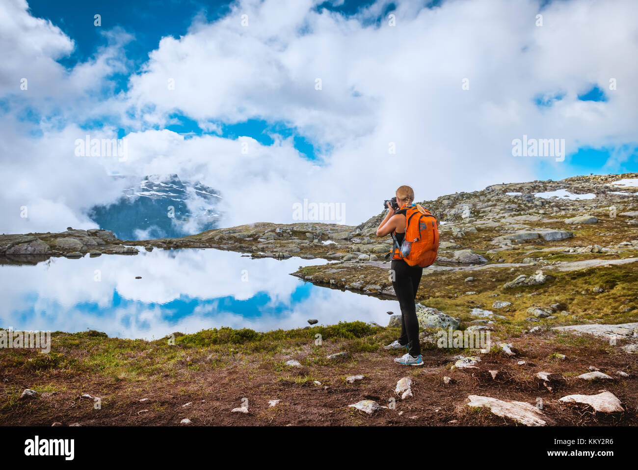 Fotografo di natura turistico con fotocamera germogli mentre permanente sulla cima della montagna. Bellissima natura della Norvegia Foto Stock