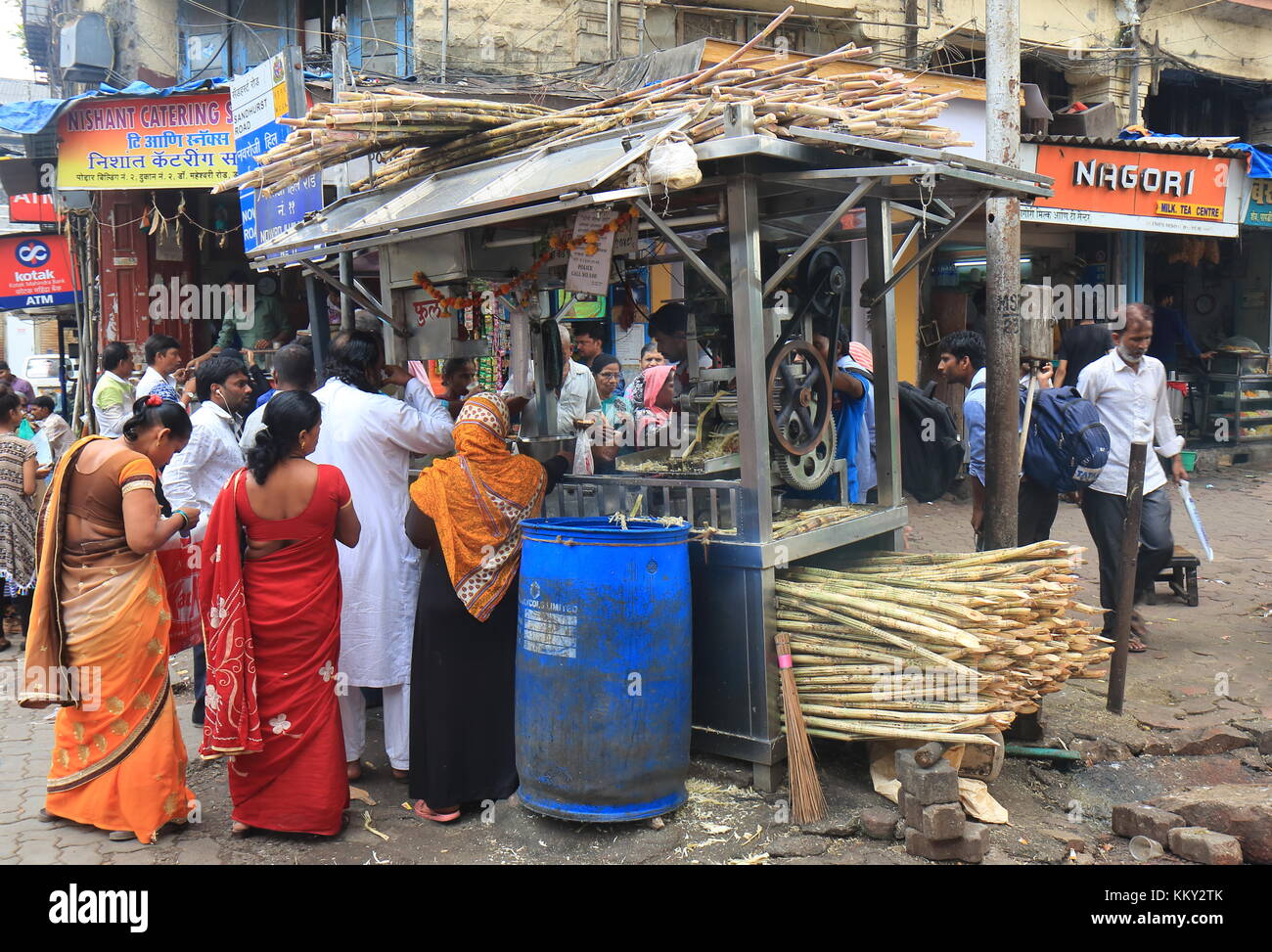 Le persone acquistano zucchero succo di canna nel centro cittadino di Mumbai in India. Foto Stock
