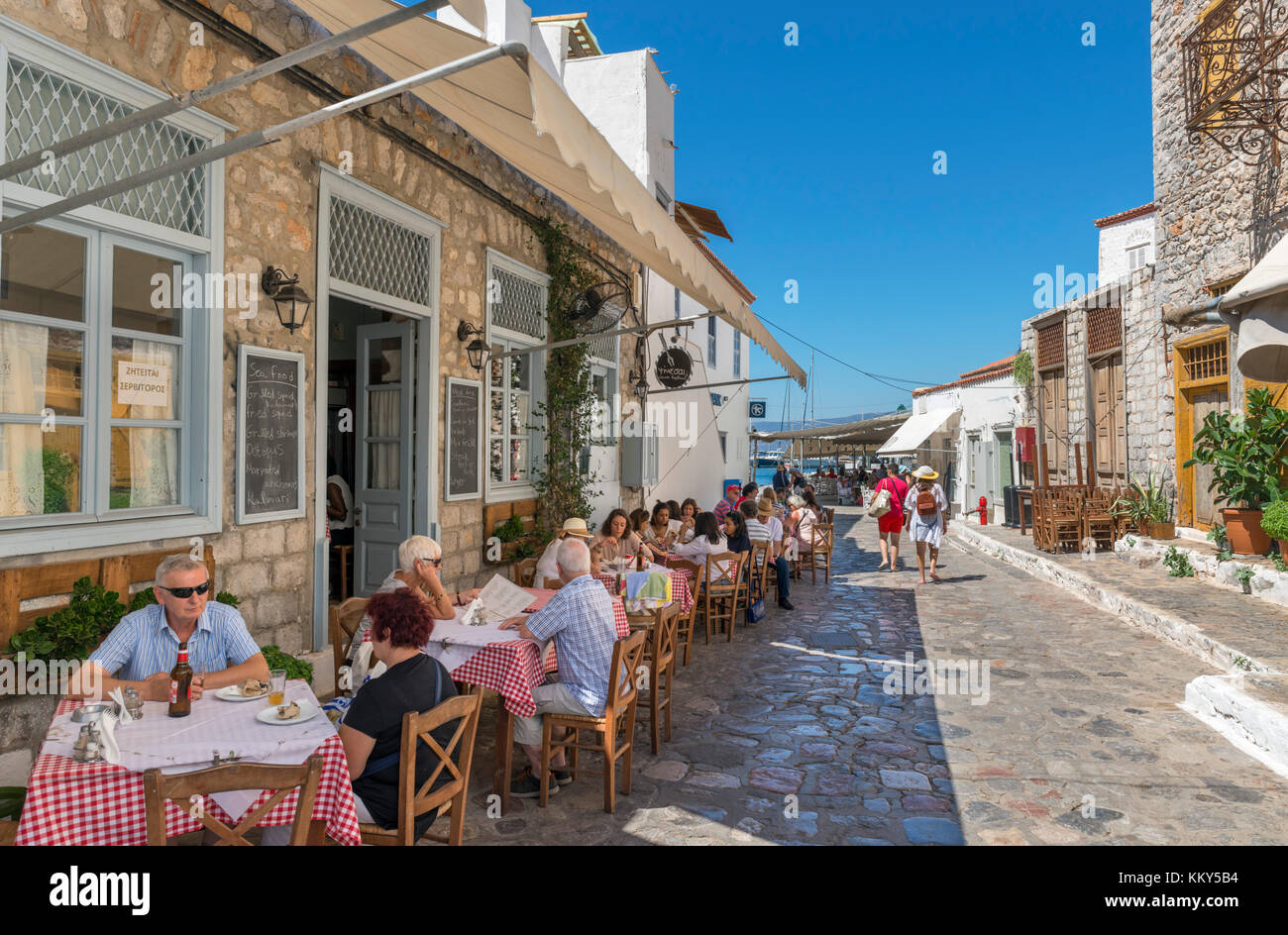 Tradizionale taverna greca su una tipica strada vicino al porto, Hydra town, Hydra, Isole Saroniche, Grecia Foto Stock