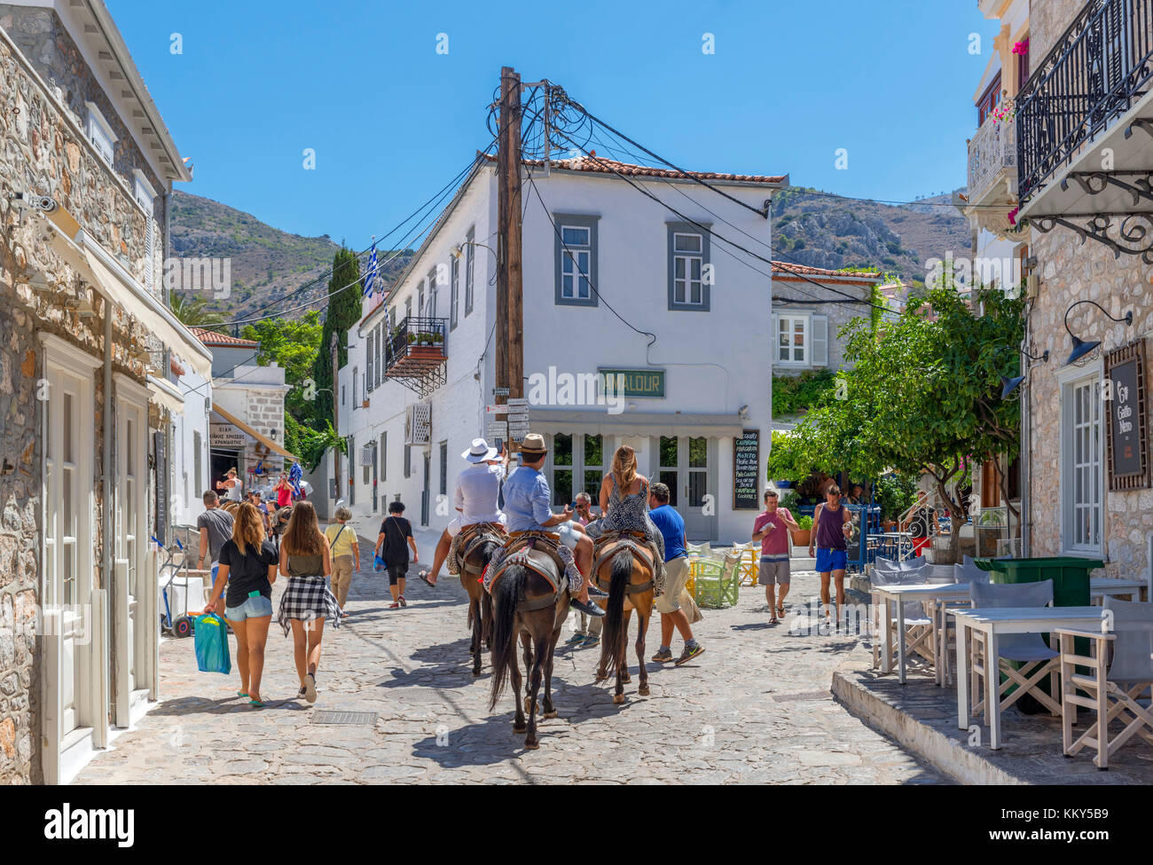 I turisti prendendo un donkey ride attraverso le strade della città di Hydra, Hydra, Isole Saroniche, Grecia Foto Stock