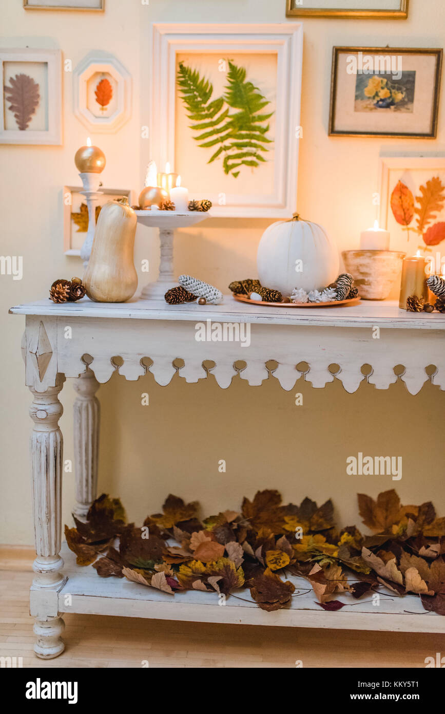 Tavolo console, decorazione autunnale, candele, cornici, foglie Foto Stock