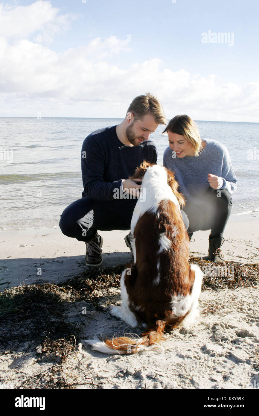 Coppia con passeggiata con i cani sulla spiaggia del Mar Baltico, Foto Stock