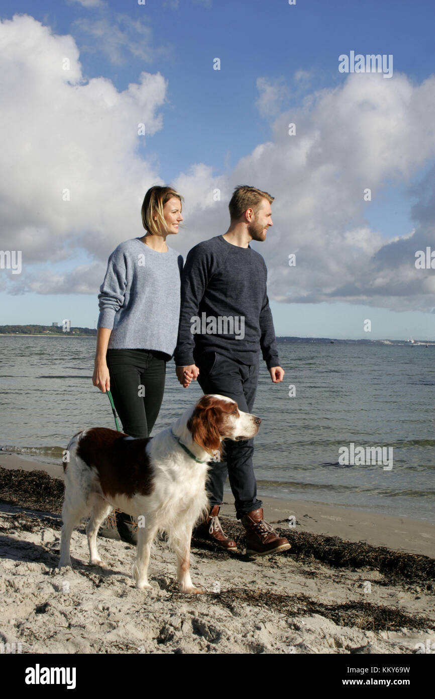 Coppia con passeggiata con i cani sulla spiaggia del Mar Baltico, Foto Stock