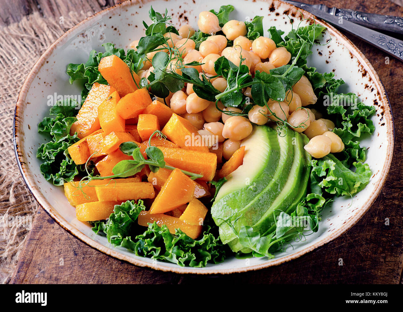 Un sano nutrimento vegetariano ciotola con ceci, verde pisello, zucca, avocado, lattuga e germogli di pisello. sana detox mangiare. vegani e vegetariani foo Foto Stock