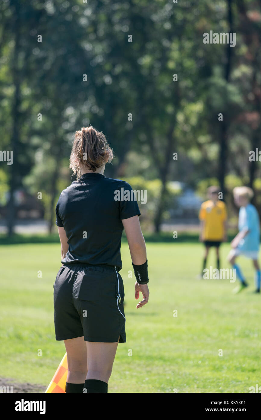 Arbitro assistente mantenendo un occhio attento sui giocatori di calcio per assicurarsi che non siano fuorigioco Foto Stock