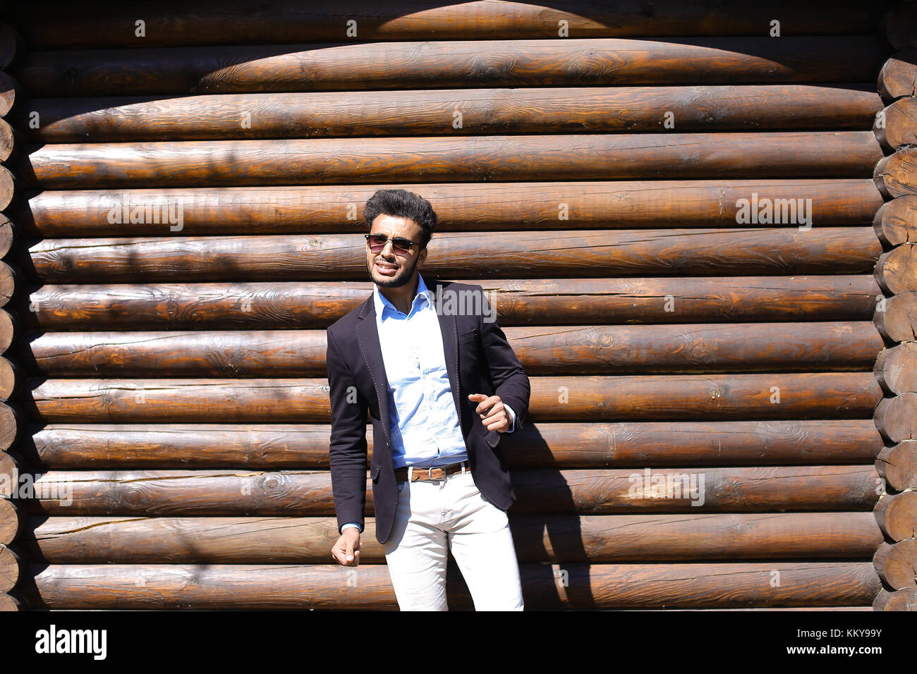 Mussola ballare e cantare canzoni. Guy ha barba e capelli corti e le fossette sulle guance. Uomo vestito con una giacca nera, bianco jeans e maglietta blu. Concetto di Foto Stock