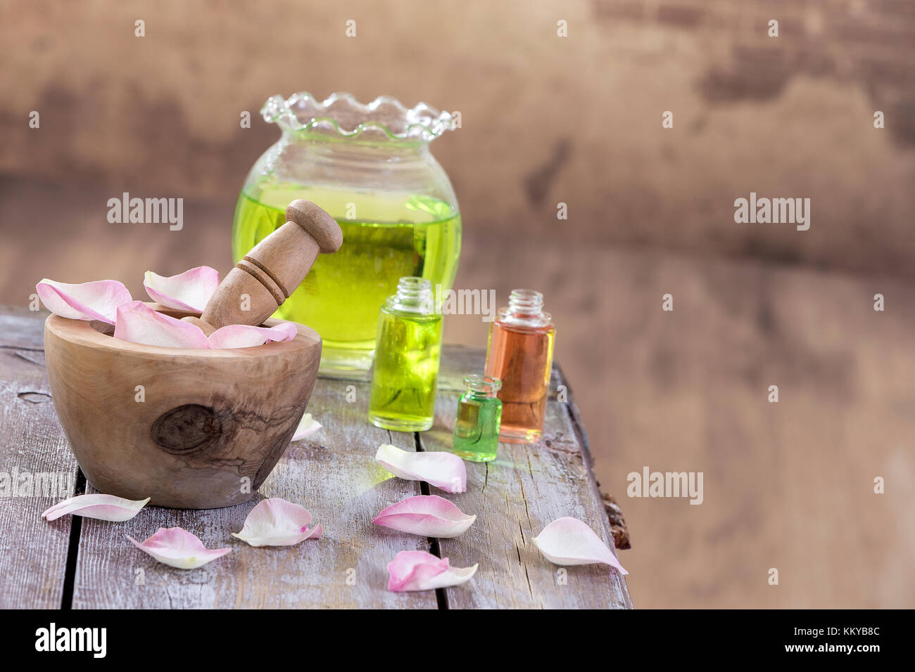 Spa e il concetto di benessere: preparazione di olio essenziale di rosa rose, bottiglia di tintura e di mortaio su una tavola di legno con tutte le parete vintage Foto Stock