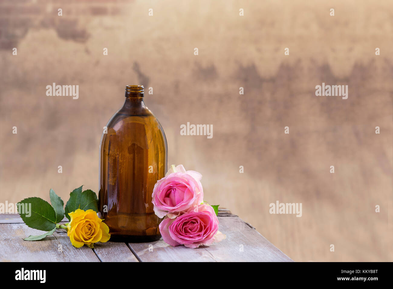 Spa e il concetto di benessere: preparazione di olio essenziale di rosa rose, bottiglia marrone di tintura su tavola di legno con un, appartment sfondo Foto Stock