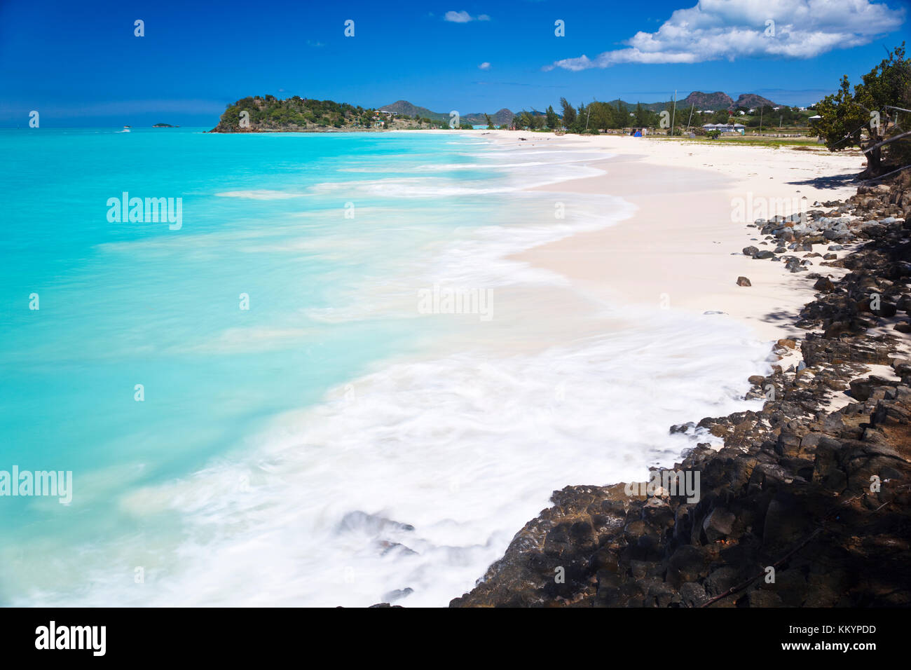 Bella spiaggia ffryes in antigua con rocce in primo piano e leggermente sfocati motion. Foto Stock