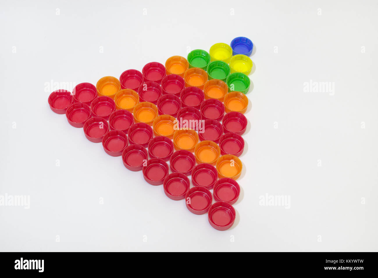 La bottiglia di plastica tappi, raccolti in regolare piramide triangolare. guardando da un angolo Foto Stock