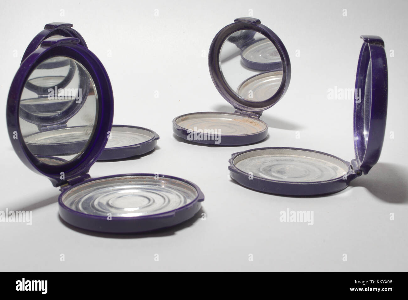 Quattro round vuoto fondazione casi in polvere con specchio, che riflettono ogni altro Foto Stock