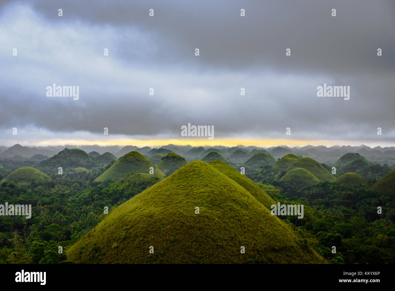 Vista panoramica del sito UNESCO delle colline di cioccolato in Bohol, Filippine, con nuvole e sole Foto Stock