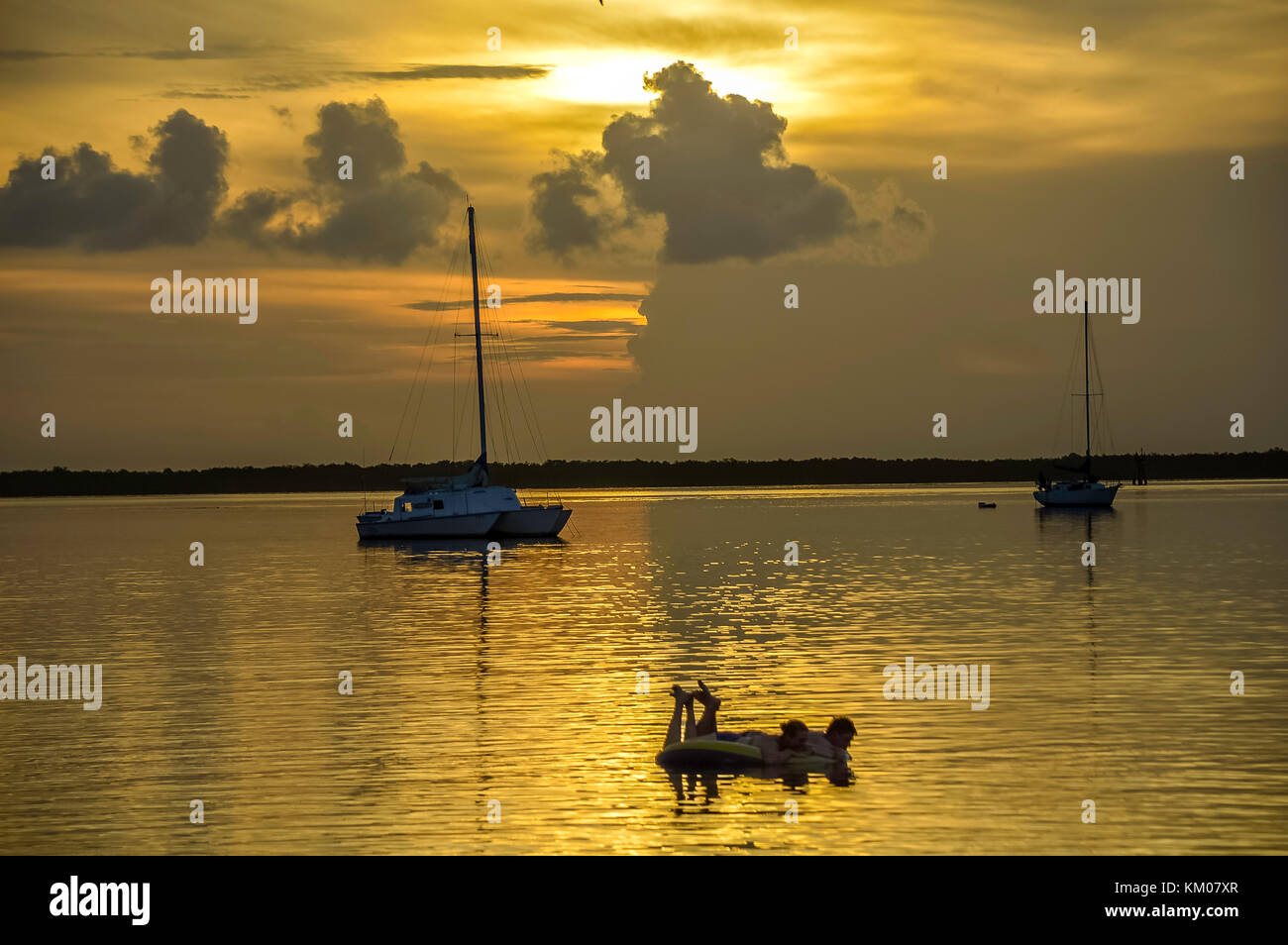 Keywest tramonto tramonto a key west florida usa con la barca e flottante silhouette di persone ora d'oro Foto Stock