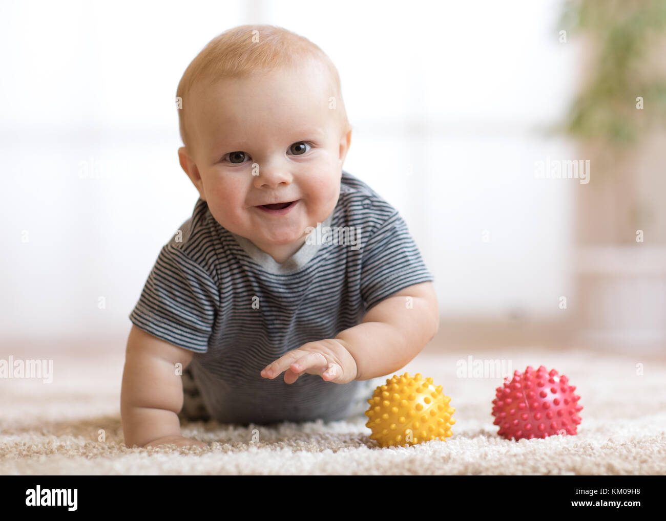 Adorable baby strisciando sul morbido tappeto a casa Foto Stock