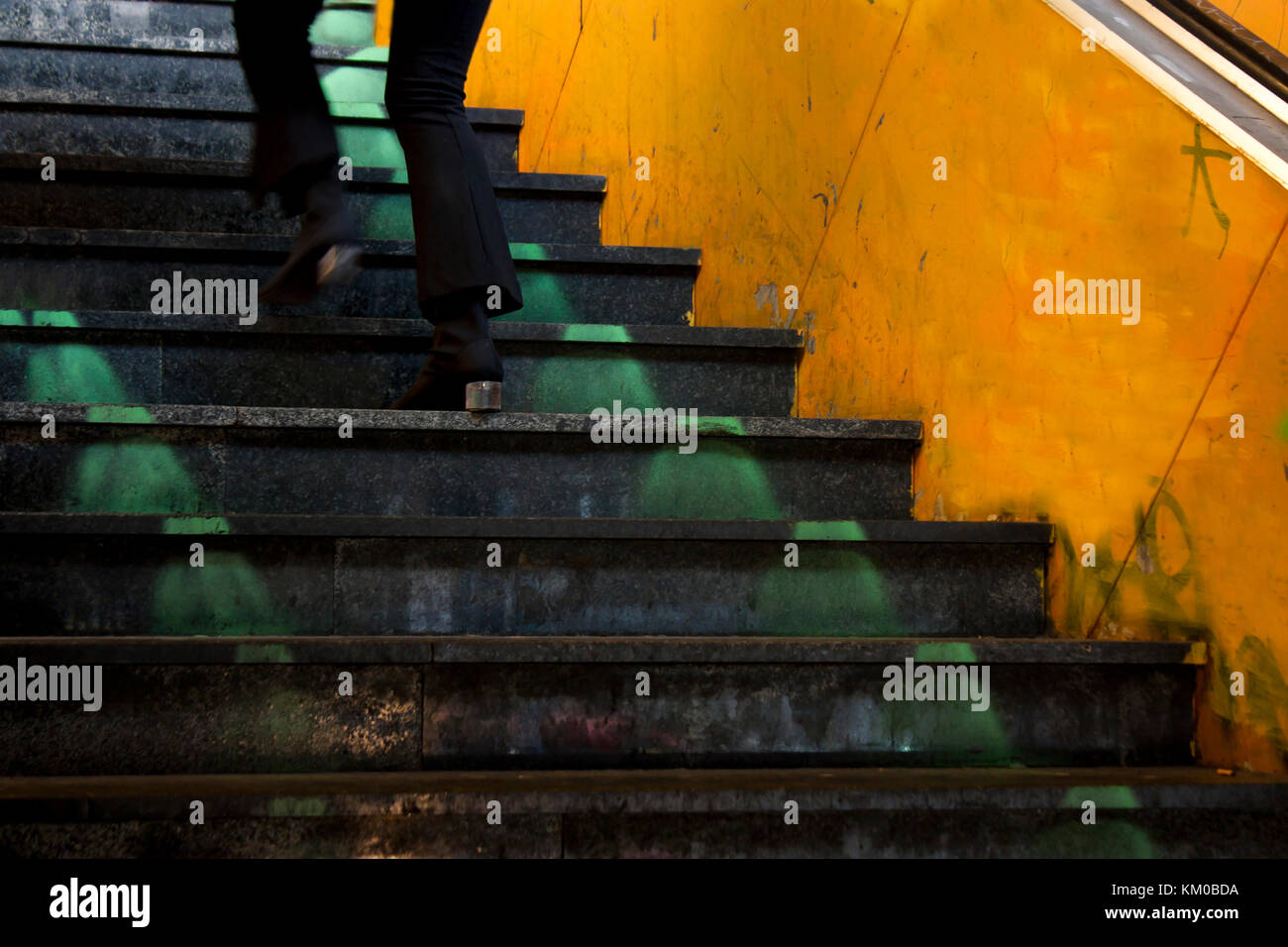 Una giovane donna gambe risalendo la vecchia città metropolitana scale in motion blur Foto Stock