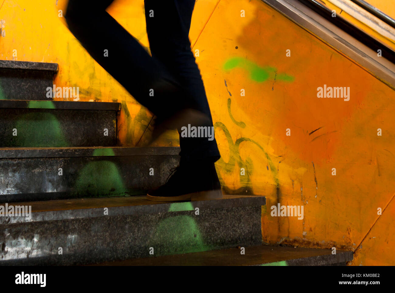 Un uomo gambe risalendo la vecchia città metropolitana scale in motion blur Foto Stock