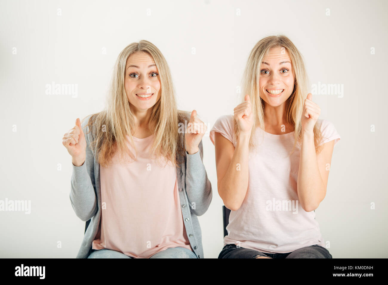 Persone, emozioni e sentimenti. twin donne aventi eccitato e look vincente Foto Stock