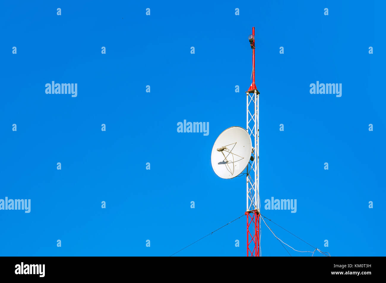 Comunicazione enorme torre per antenna e parabole satellitari contro il cielo blu. Foto Stock