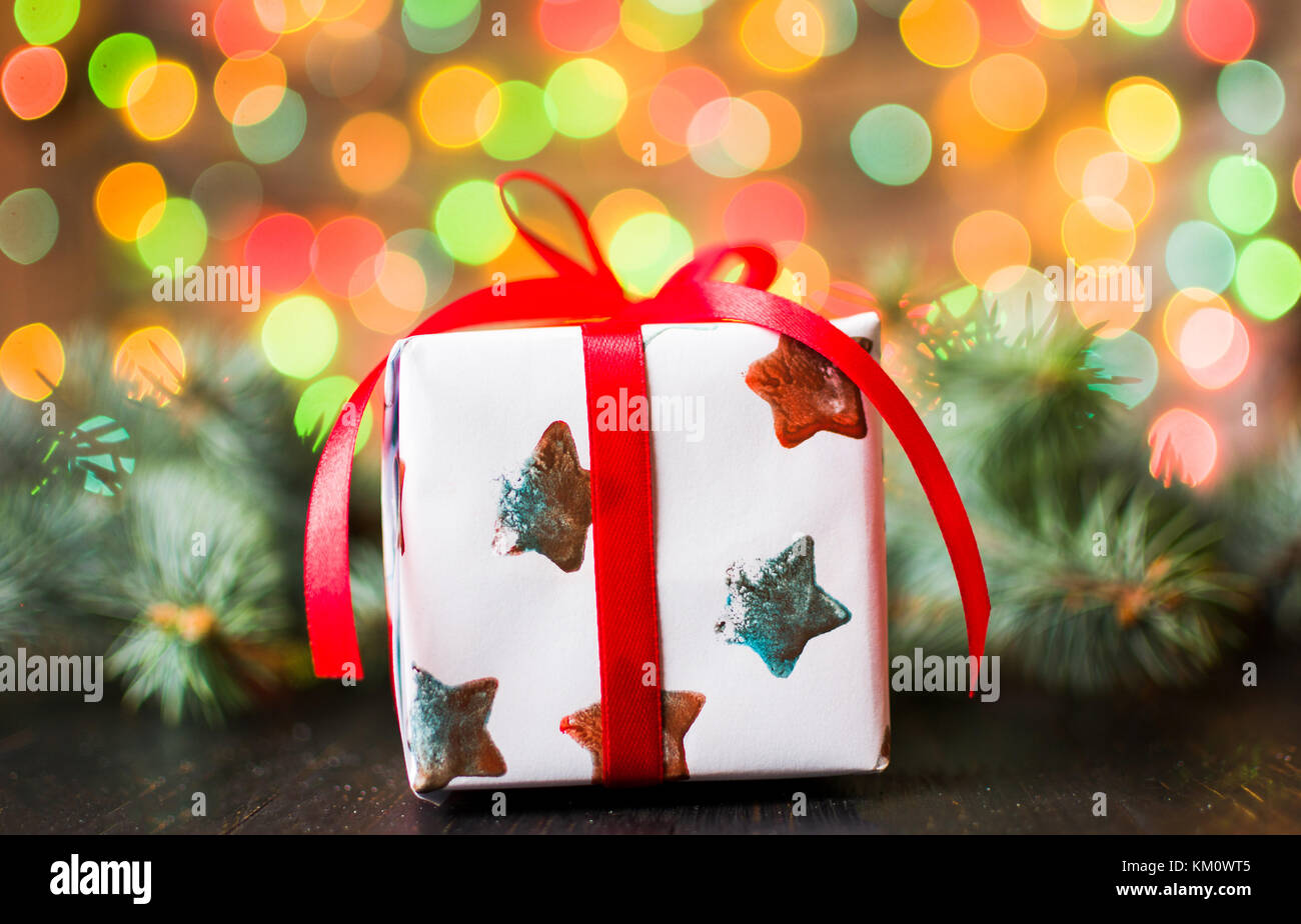 Casella presente nella parte anteriore di un albero di natale con sfondo di festa Foto Stock