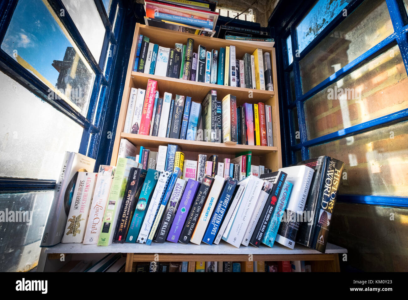 Un libro exchange comunità book library set fino a un vecchio telefono BT casella per aiutare le persone a riciclare i libri Foto Stock