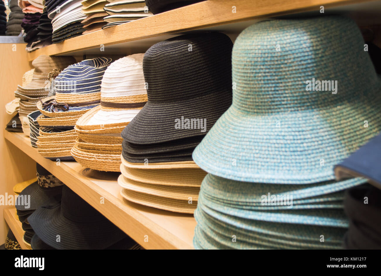Righe di colorato cappello da sole e Panama cappelli impilati su mensole in hat shop Foto Stock