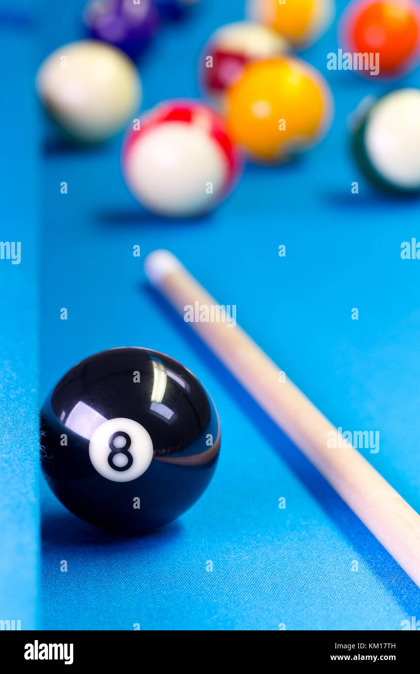 Piscina Biliardo gioco palla otto con sfere eightball e cue sul tavolo da biliardo con panno blu, il fuoco selettivo sulla palla otto Foto Stock