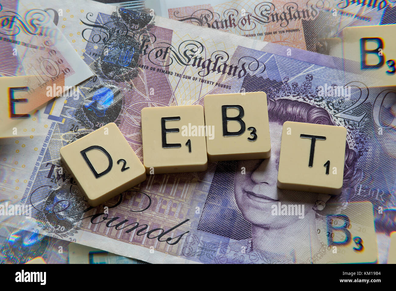 Lettere di scrabble debito controllo ortografico con nuove sterline inglesi (GBP) £20, £10, £5 note e la nuova British pound monete. Foto Stock