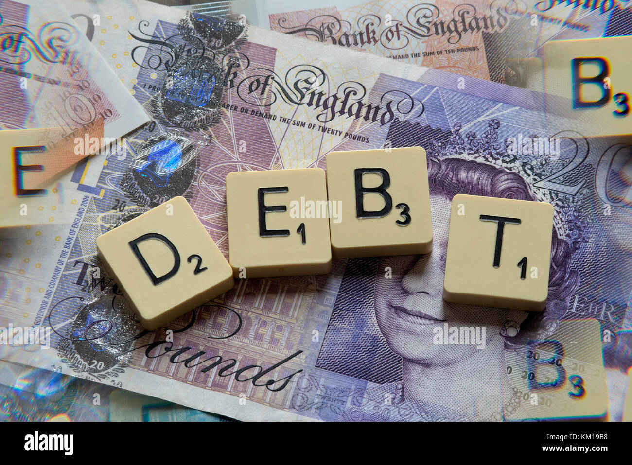 Lettere di scrabble debito controllo ortografico con nuove sterline inglesi (GBP) £20, £10, £5 note e la nuova British pound monete. Foto Stock