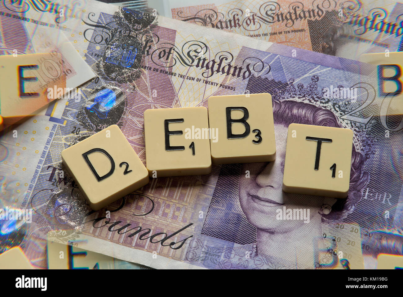 Lettere di scrabble debito controllo ortografico con nuove sterline inglesi (GBP) £20, £10, £5 note e la nuova British pound monete. Foto Stock