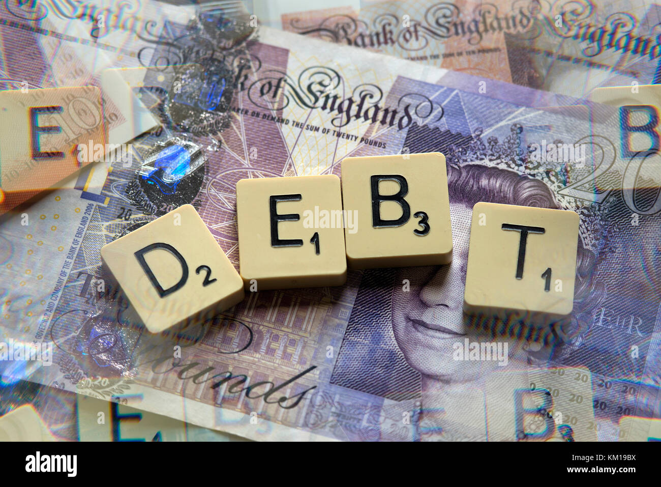 Lettere di scrabble debito controllo ortografico con nuove sterline inglesi (GBP) £20, £10, £5 note e la nuova British pound monete. Foto Stock