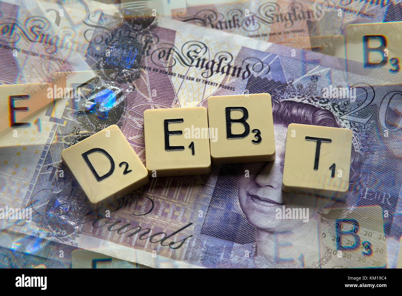Lettere di scrabble debito controllo ortografico con nuove sterline inglesi (GBP) £20, £10, £5 note e la nuova British pound monete. Foto Stock