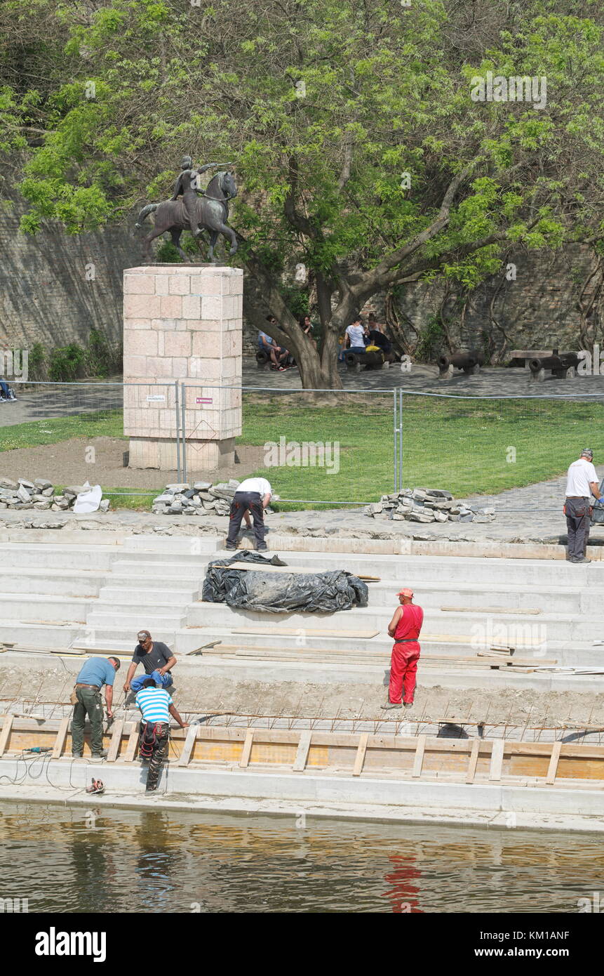Una mezza dozzina di uomini di lavoro rinnovando il raba banca di fiume Foto Stock