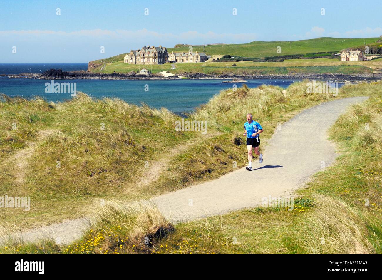 Jogging sulle dune di sabbia di Runkerry Strand, Portballintrae vicino a Bushmills e Portrush, contea di Antrim, Irlanda del Nord. Estate Foto Stock