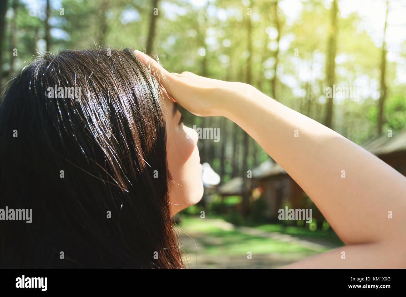 Ragazza asiatica che copre gli occhi dal sole Foto Stock