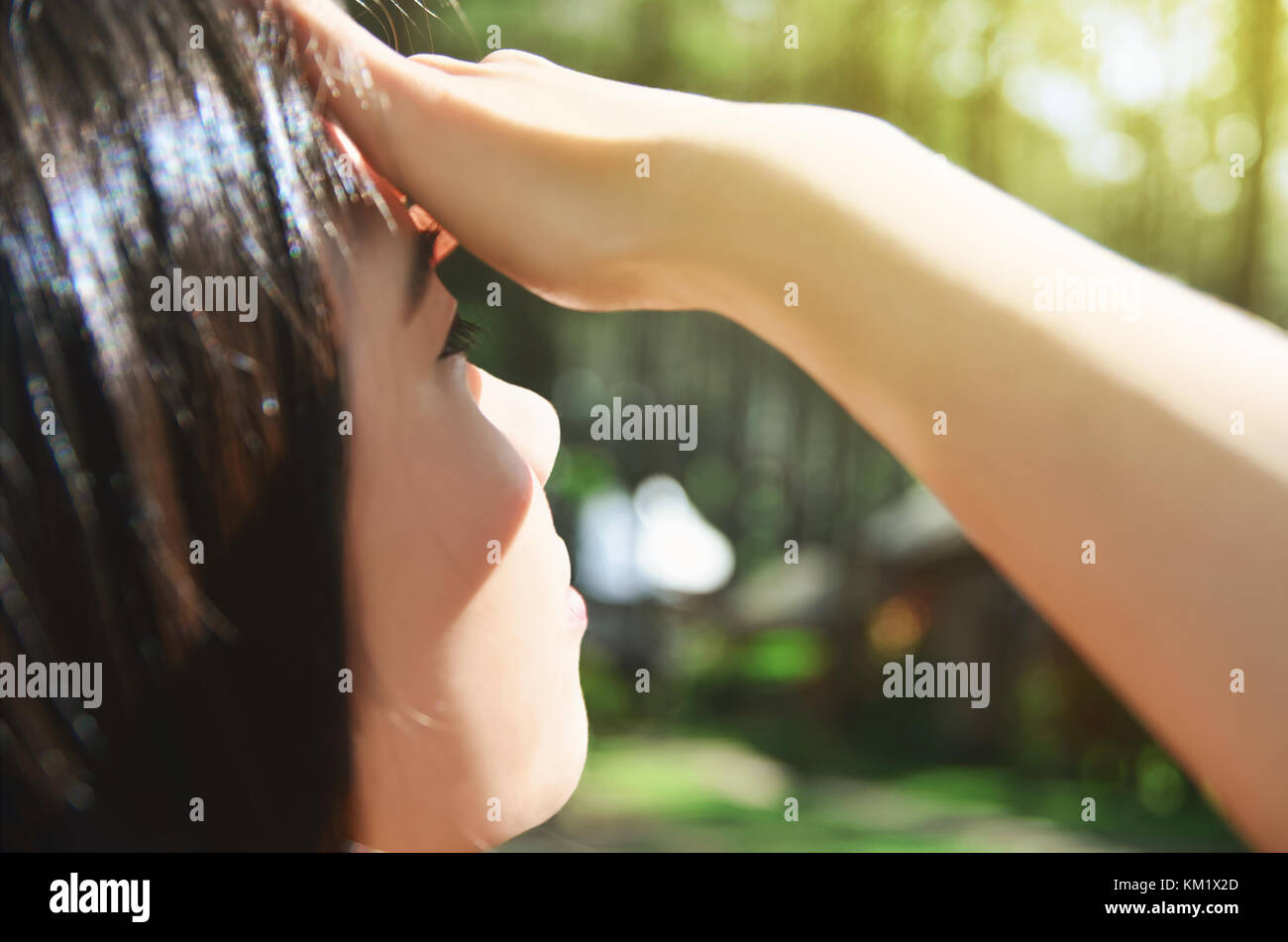 Ragazza asiatica che copre gli occhi dal sole Foto Stock