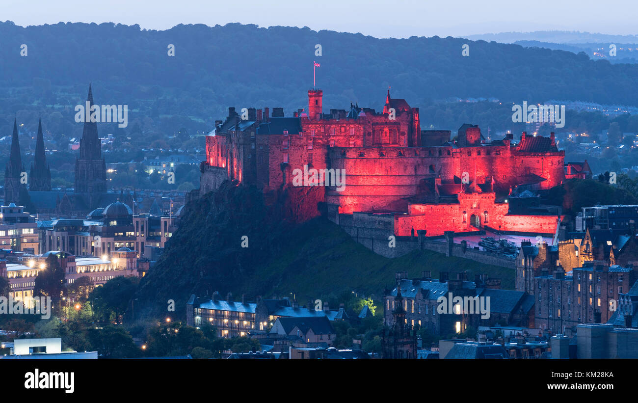 Vista serale del Castello di Edimburgo illuminata in rosso da Salisbury Crags, Edimburgo, Scozia, Regno Unito. Foto Stock