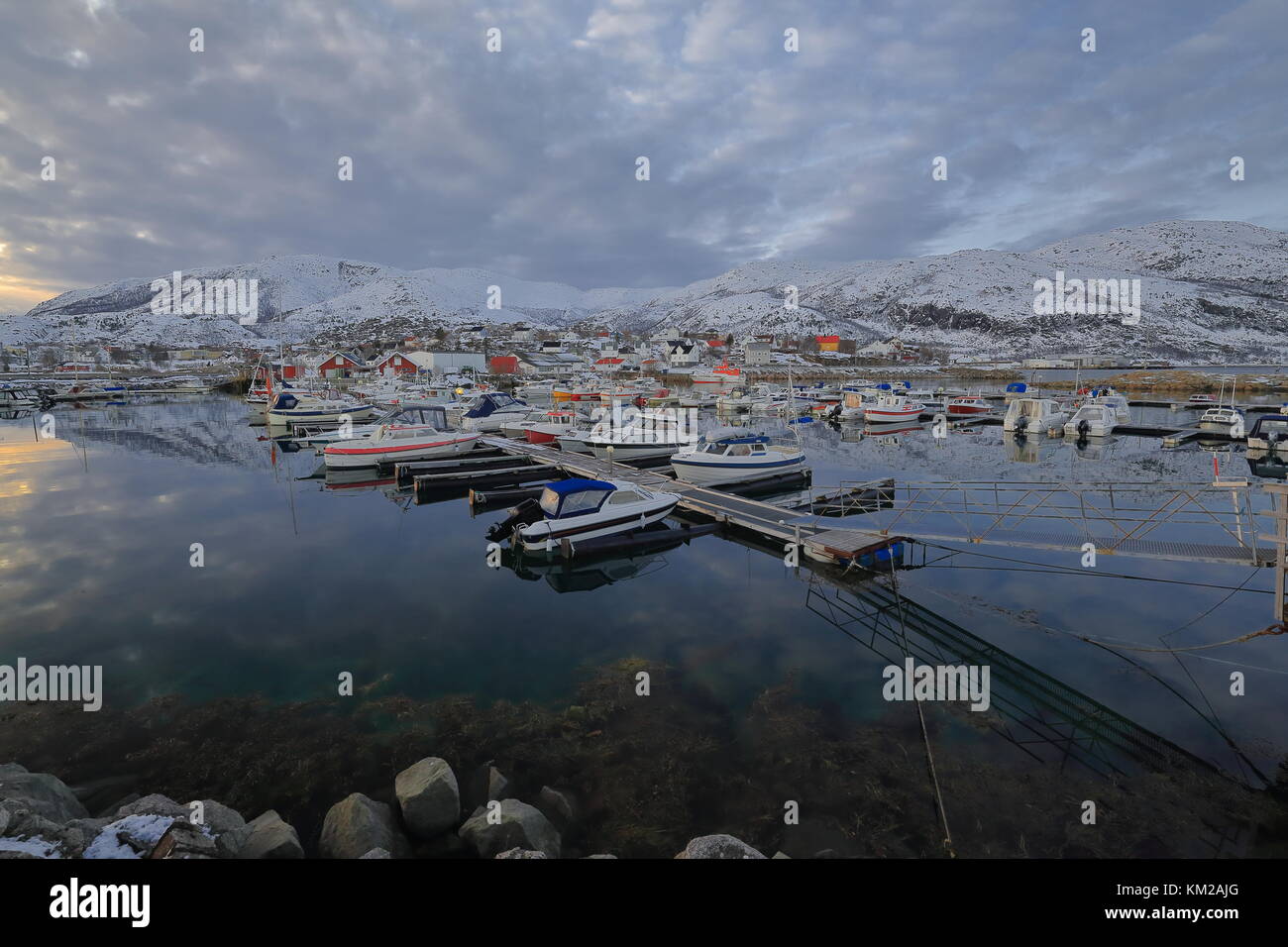 W.-reparti vista sul porto pieno di barche da pesca ormeggiate ai pontili galleggianti. cielo nuvoloso su bufjellet-nygardsfjellte colline e lodingsaksla mount Foto Stock