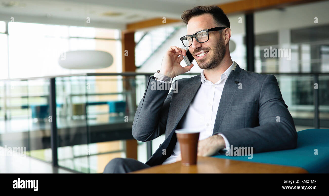 Pensieroso giovane imprenditore nel cafe usando il telefono Foto Stock