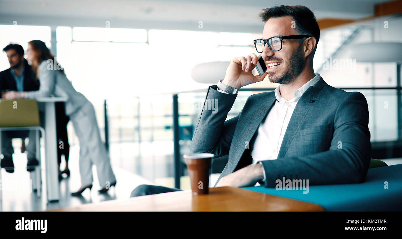 Pensieroso giovane imprenditore nel cafe usando il telefono Foto Stock