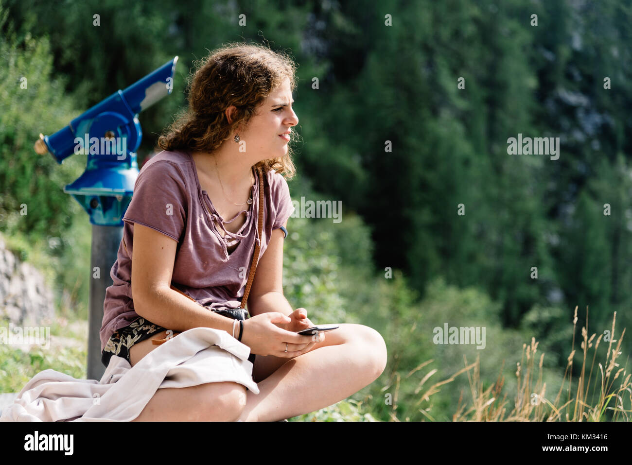 Ritratto di giovane donna guardando il paesaggio e seduta in vista Foto Stock