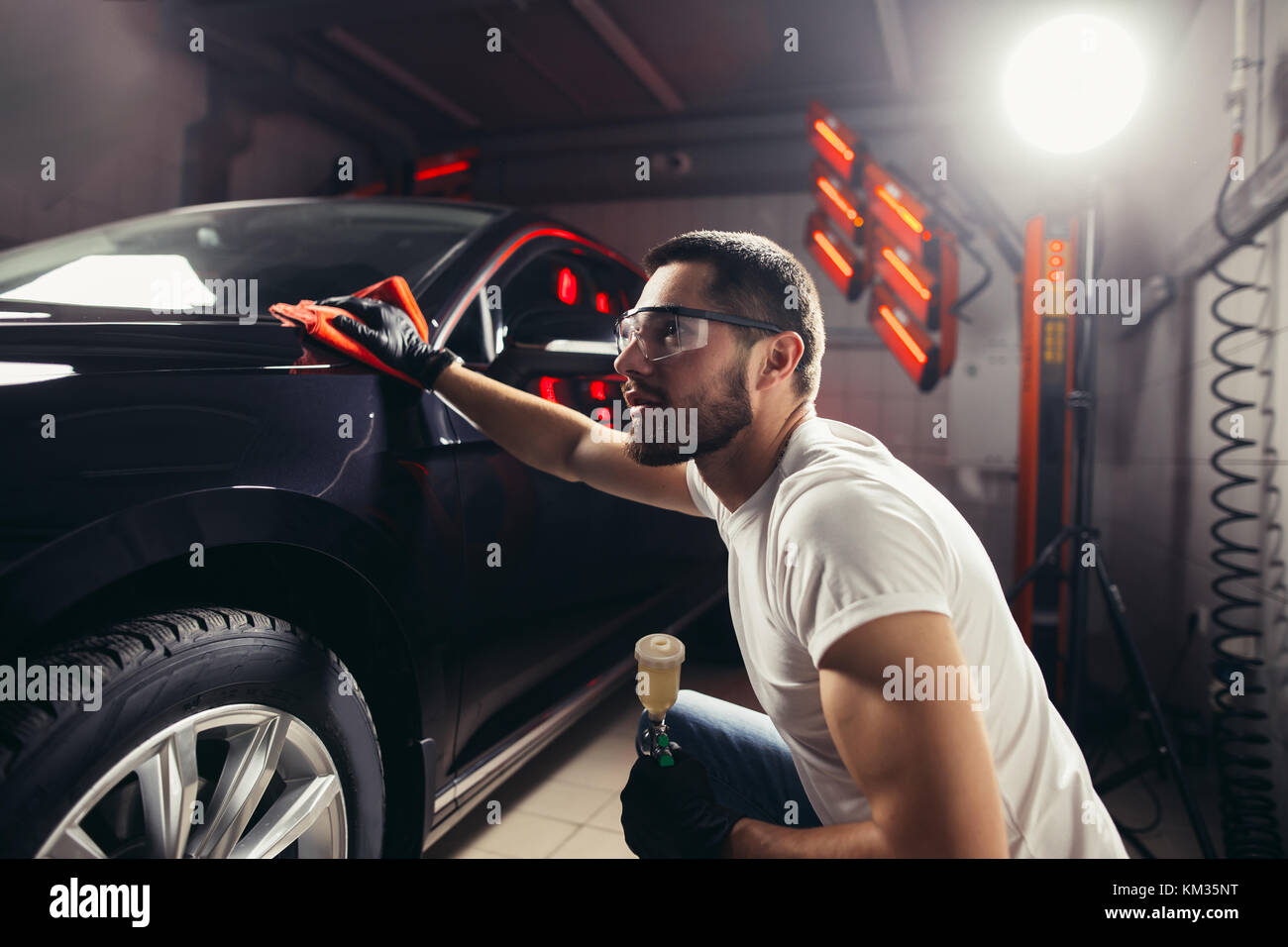 Dettagli auto - l'uomo detiene la microfibra in mano e leviga la vettura Foto Stock