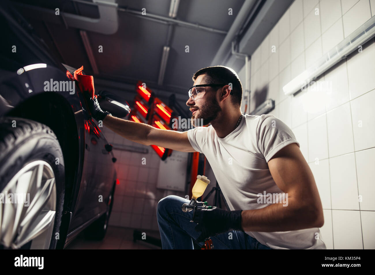 Dettagli auto - l'uomo detiene la microfibra in mano e leviga la vettura Foto Stock