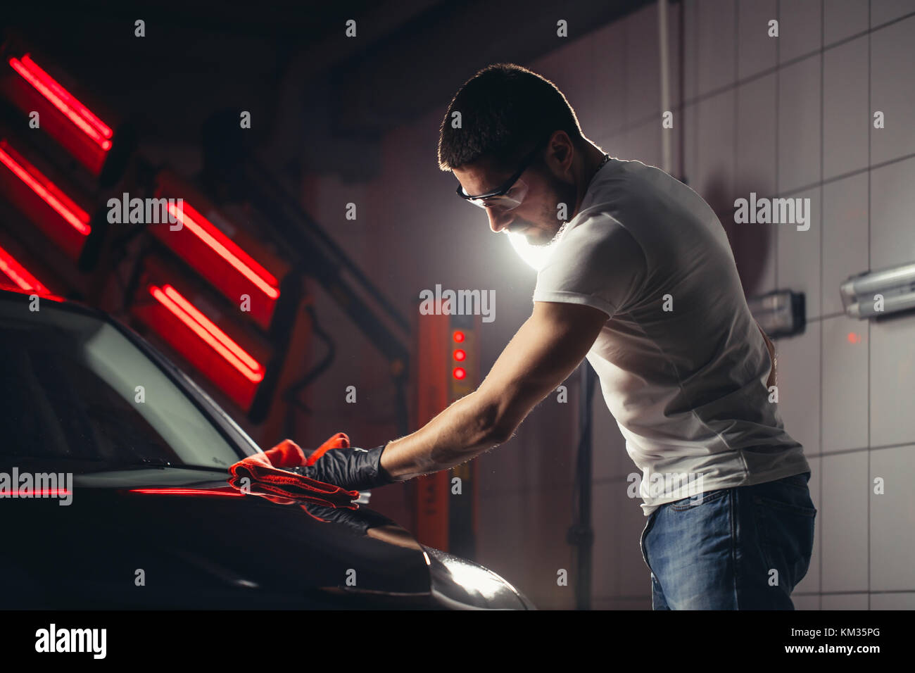 Dettagli auto - l'uomo detiene la microfibra in mano e leviga la vettura Foto Stock