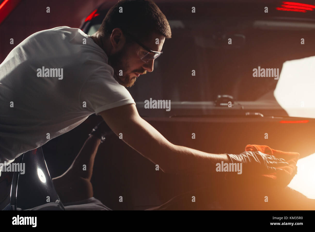 Dettagli auto - l'uomo detiene la microfibra in mano e leviga la vettura Foto Stock
