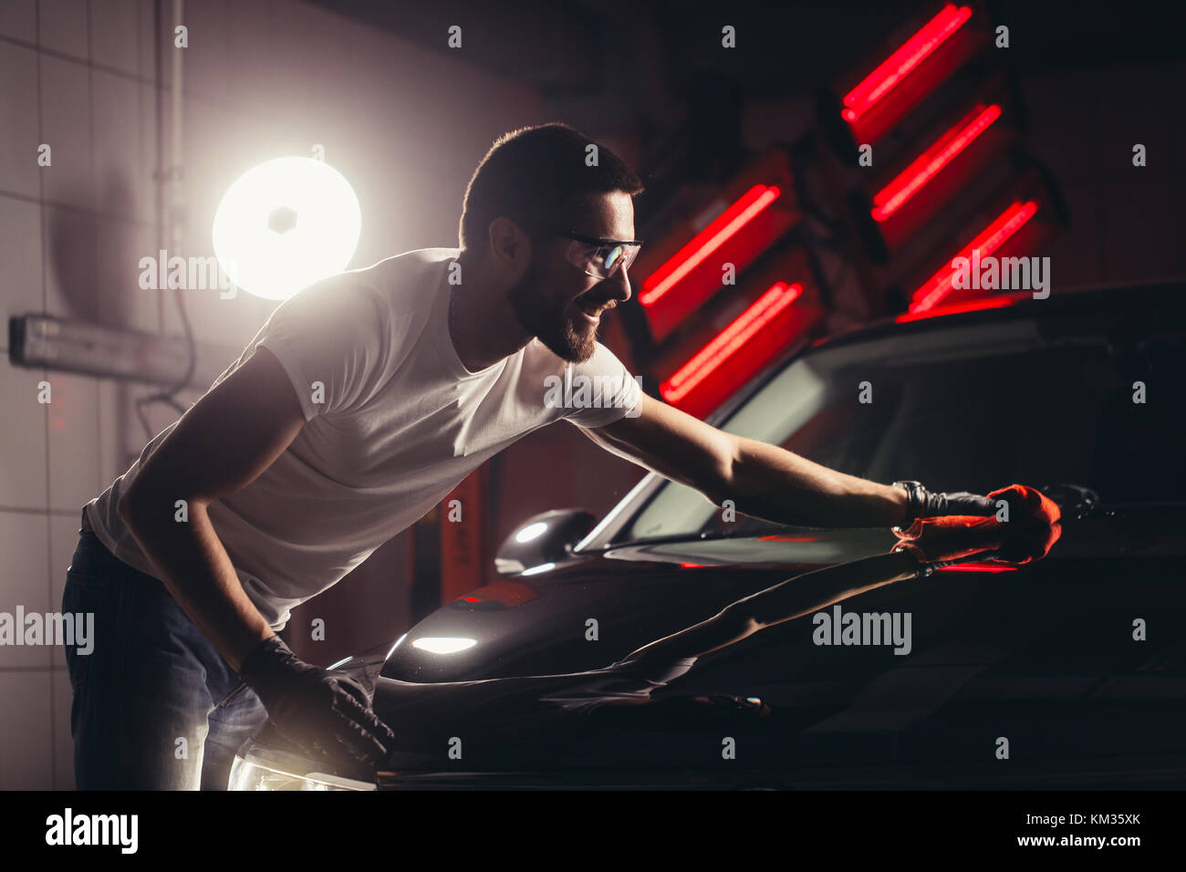 Dettagli auto - l'uomo detiene la microfibra in mano e leviga la vettura Foto Stock