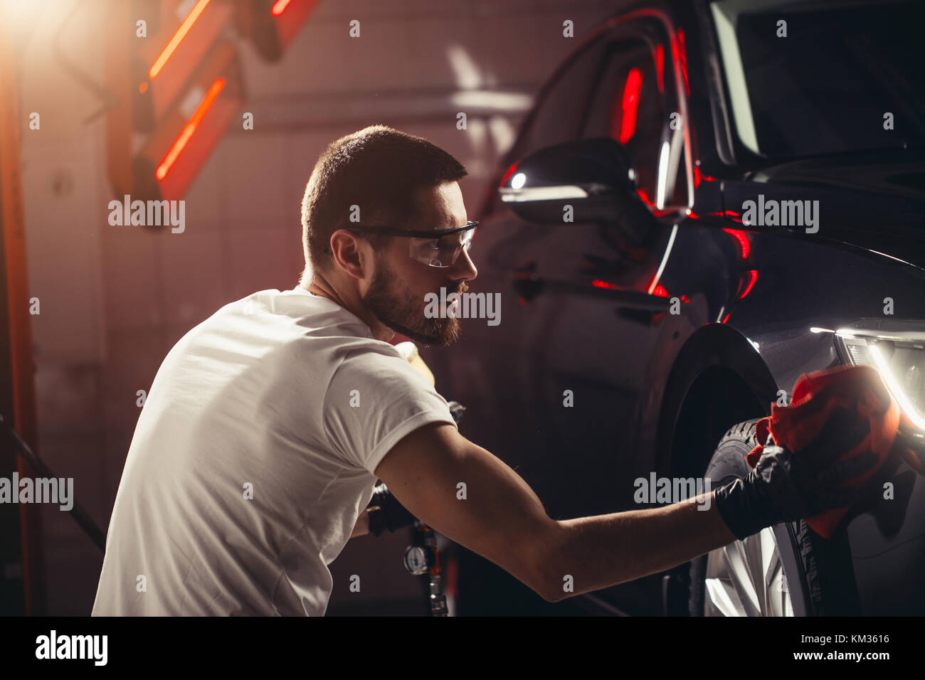 Dettagli auto - l'uomo detiene la microfibra in mano e leviga la vettura Foto Stock