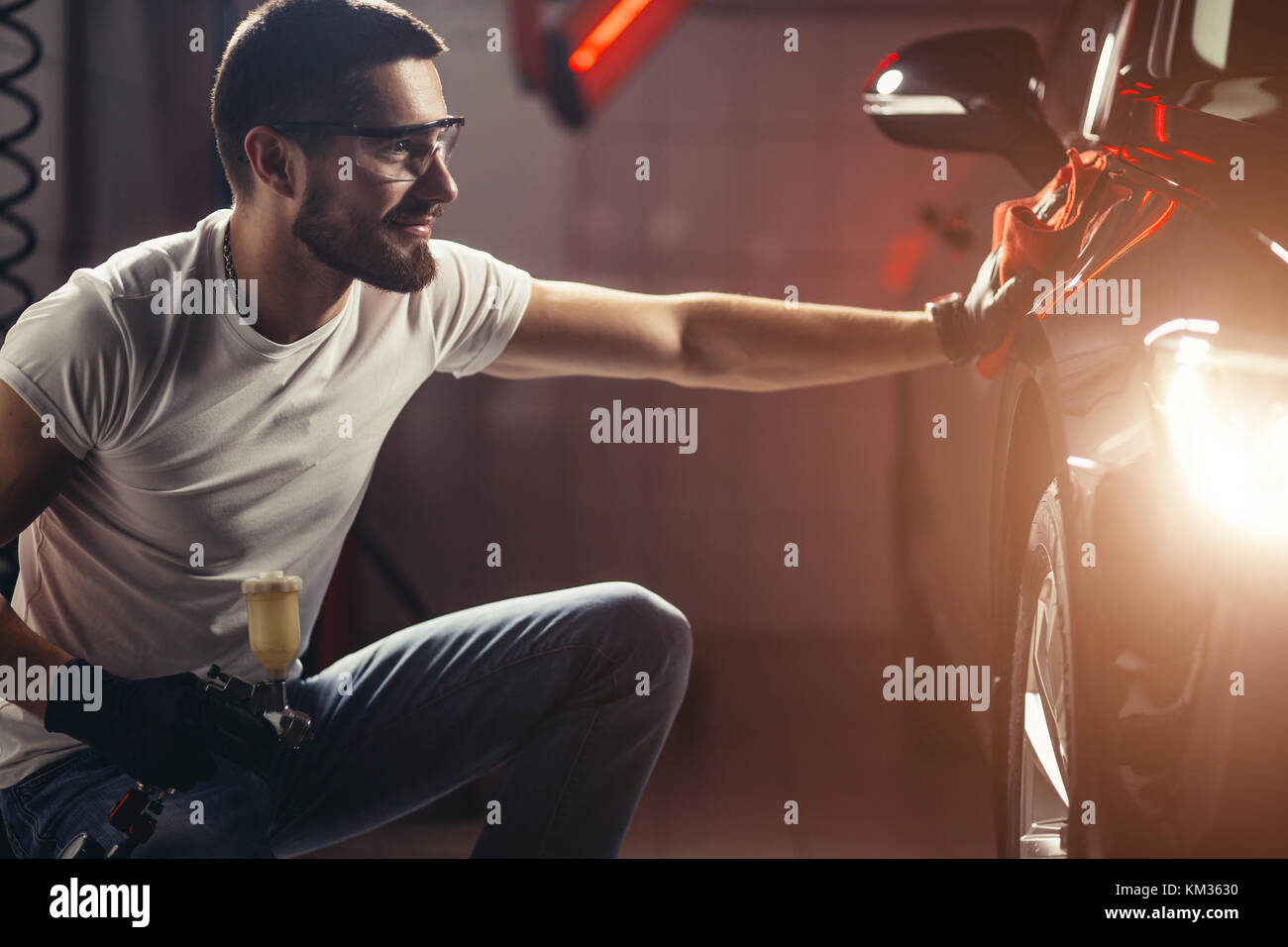 Dettagli auto - l'uomo detiene la microfibra in mano e leviga la vettura Foto Stock