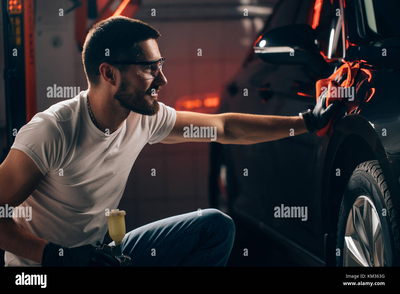 Dettagli auto - l'uomo detiene la microfibra in mano e leviga la vettura Foto Stock