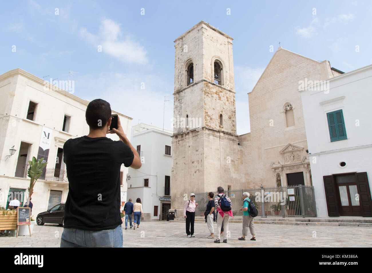 Ignano a Mare, Italia - 2 Ottobre 2017: un giovane uomo di scattare una foto nella piazza di Polignano a Mare una piccola città costruita sulle rocce. Foto Stock