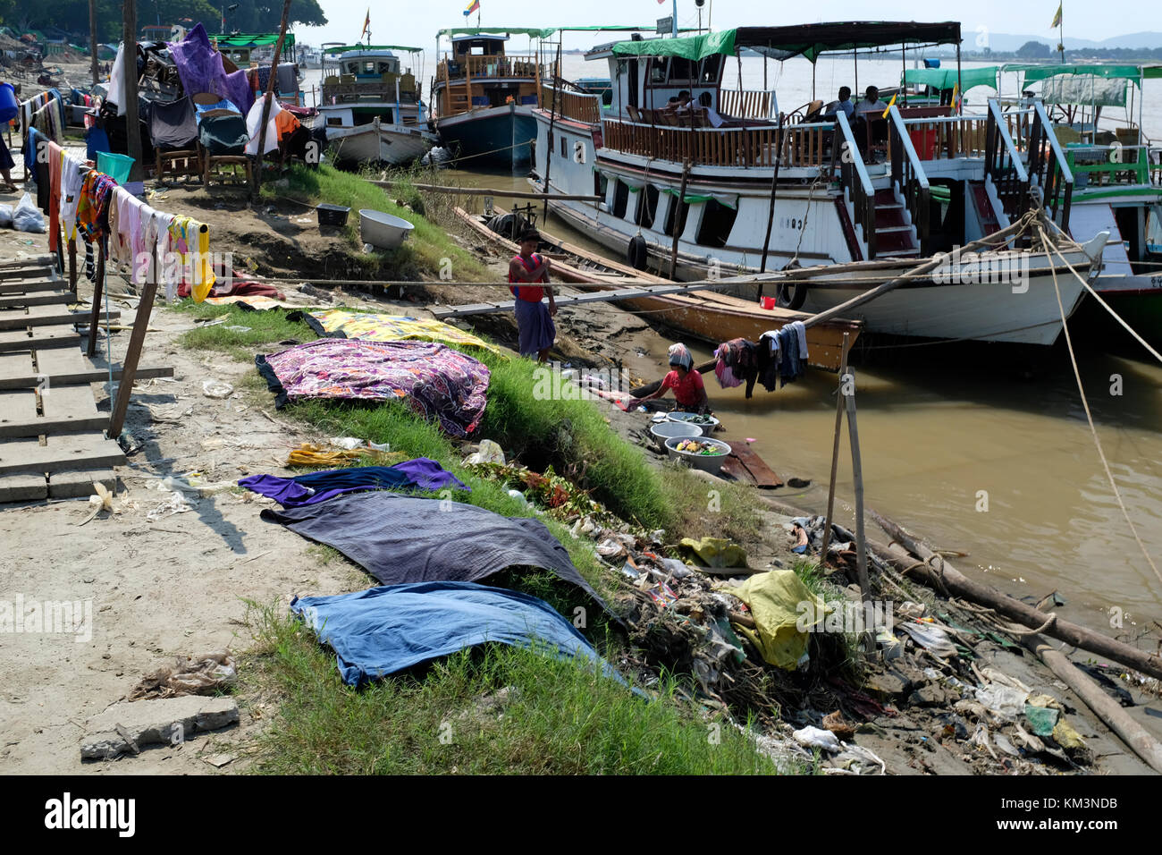 Lavare i panni lungo le rive del fiume Irrawaddy in Mandalay, Myanmar Foto Stock